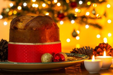 Dekorasyonlu panettone, Noel ağacı ve arka planda yanıp sönen ışıklar..