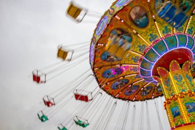 Bulutlu bir günde eğlence parkında birkaç kişiyle dönen dev bir bisiklet sürüşünün ayrıntıları. Fotoğraf aşağıdan yukarıya doğru çekilmiş.