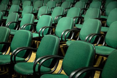  Konferans salonunda birkaç sıra yeşil sandalye..