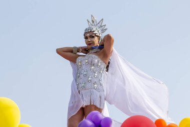 Brezilya 'nın Goinia şehrindeki 2024 LGBT Onur Yürüyüşü' nde beyaz giyinmiş, dans eden bir LGBT çalışanı..