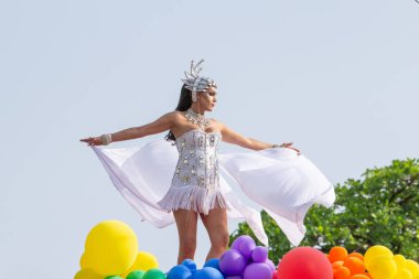 Brezilya 'nın Goinia şehrindeki 2024 LGBT Onur Yürüyüşü' nde beyaz giyinmiş, dans eden bir LGBT çalışanı..