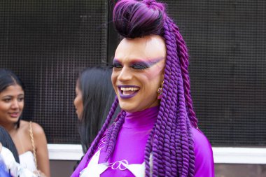 A happy person, dressed all in purple, with purple hair, at the LGBT Pride parade in the city of Goiania. clipart