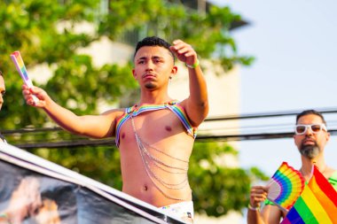 Goiania şehrindeki LGBT Onur Yürüyüşü 'nde elektrikli üçlünün tepesinde dans eden çocuklar..