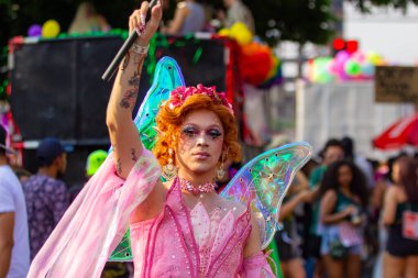 Goiania şehrindeki LGBT Onur Yürüyüşü sırasında sokakta dans eden, pembeli bir trans kadın..