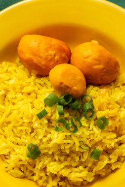 Vertical image of a super close up on a yellow plate with rice with pequi. Typical food from Gois. clipart