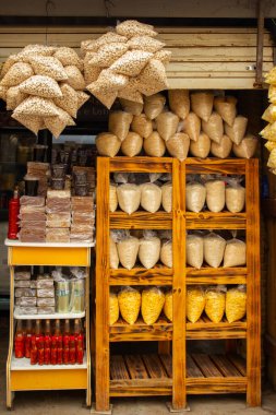 Yiyecek ürünleri raflarda, masalar da bir mağazanın kapısında sergileniyor..