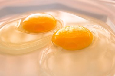 Beyaz bir porselen tabakta iki çiğ yumurta..