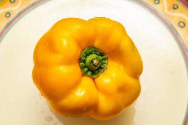 Bir porselen tabağın içinde sarı biber.