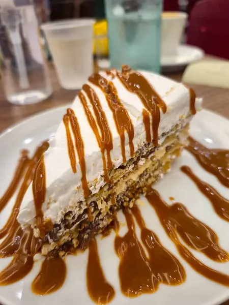 Ön planda bir parça turta, alışveriş merkezindeki bir fırının masasında servis ediliyor..