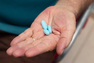 Üç viagra haplı yaşlı bir adamın eli..