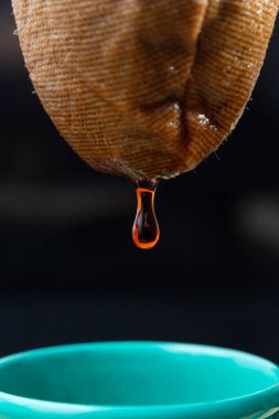 Siyah arka planda kahve damlayan bir süzgecin ayrıntıları.