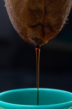 Kahvenin ayrıntıları siyah arka planı olan yeşil bir diş minesi bardağına dökülüyor..