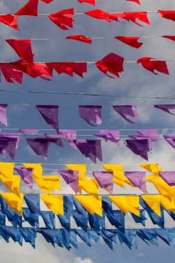 Birçok renkli bayraklı çamaşır ipleri - kırmızı, mor, sarı ve mavi. Kare dansı için dekorasyon - tipik bir Brezilyalı partisi.