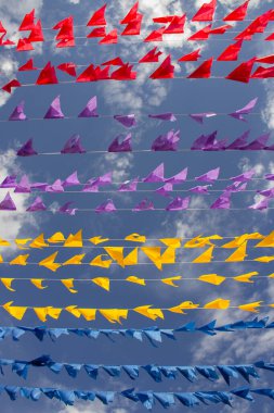 Rüzgarda dalgalanan birçok bayrak, gökyüzü ve arka planda bulutlar olan birkaç çamaşır ipi. Kare dansı için dekorasyon, tipik bir Brezilya partisi..