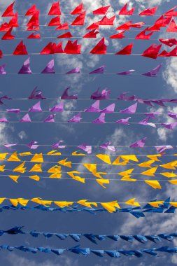 Rüzgarda dalgalanan birçok bayrak, gökyüzü ve arka planda bulutlar olan birkaç çamaşır ipi. Kare dansı için dekorasyon, tipik bir Brezilya partisi..