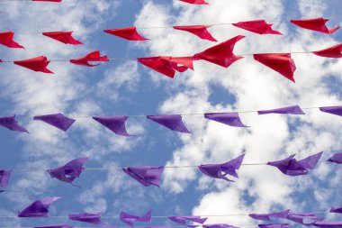 Rüzgarda sallanan birçok kırmızı ve mor bayraklı çamaşır ipleri. Kare dansı için dekorasyon - tipik bir Brezilyalı partisi.