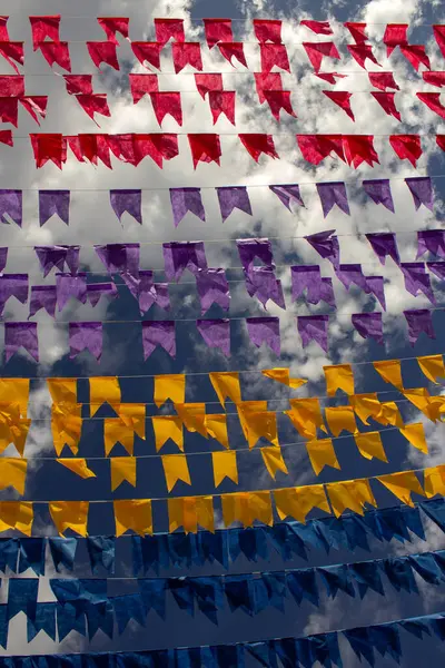 Rüzgarda dalgalanan birçok bayrak, gökyüzü ve arka planda bulutlar olan birkaç çamaşır ipi. Kare dansı için dekorasyon, tipik bir Brezilya partisi..