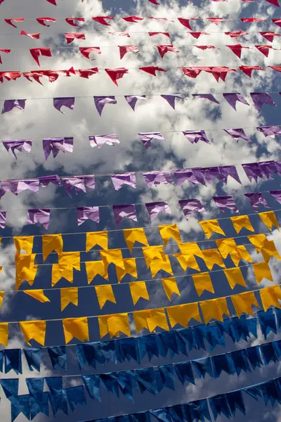 Rüzgarda dalgalanan birçok bayrak, gökyüzü ve arka planda bulutlar olan birkaç çamaşır ipi. Kare dansı için dekorasyon, tipik bir Brezilya partisi..