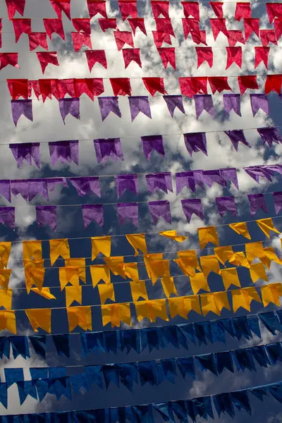 Rüzgarda dalgalanan birçok bayrak, gökyüzü ve arka planda bulutlar olan birkaç çamaşır ipi. Kare dansı için dekorasyon, tipik bir Brezilya partisi..