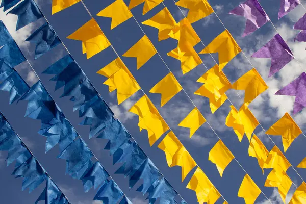 Renkli flama çizgileri, mavi, sarı ve mor, arka planda mavi bir gökyüzü. Rüzgarda sallanıyor.