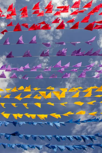 Rüzgarda dalgalanan birçok bayrak, gökyüzü ve arka planda bulutlar olan birkaç çamaşır ipi. Kare dansı için dekorasyon, tipik bir Brezilya partisi..