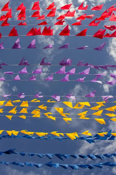 Rüzgarda dalgalanan birçok bayrak, gökyüzü ve arka planda bulutlar olan birkaç çamaşır ipi. Kare dansı için dekorasyon, tipik bir Brezilya partisi..