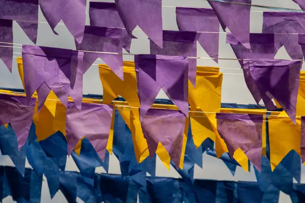 Üzerlerinde renkli flamalar asılı bazı ipler. Tam kare. Arka planda mavi gökyüzü.