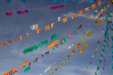 Gökyüzünde asılı bir sürü renkli flamalı birkaç çamaşır ipi ve arka planda bazı bulutlar. Kare dansı için dekorasyon - tipik bir Brezilyalı partisi.
