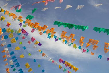 Gökyüzünde asılı bir sürü renkli flamalı birkaç çamaşır ipi ve arka planda bazı bulutlar. Kare dansı için dekorasyon - tipik bir Brezilyalı partisi.
