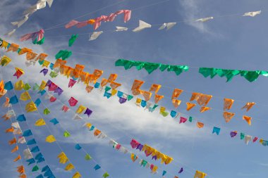 Gökyüzünde asılı bir sürü renkli flamalı birkaç çamaşır ipi ve arka planda bazı bulutlar. Kare dansı için dekorasyon - tipik bir Brezilyalı partisi.