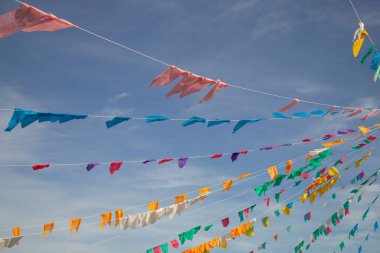 Arka planda mavi bir gökyüzü asılı renkli flama dizileri. Kare dansı için dekorasyon - tipik bir Brezilyalı partisi.