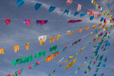 Gökyüzünde asılı bir sürü renkli flamalı birkaç çamaşır ipi ve arka planda bazı bulutlar. Kare dansı için dekorasyon - tipik bir Brezilyalı partisi.