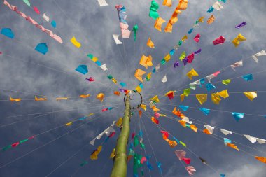 Arka planda gökyüzü asılı çeşitli renkli bayraklı bir dizi ip. Haziran festivali için dekorasyon - tipik bir Brezilya festivali.