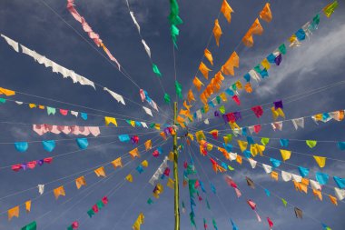 Arka planda gökyüzü asılı renkli flama ipleri olan bir set. Kare dansı için dekorasyon - tipik bir Brezilyalı partisi.
