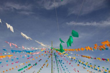 Arka planda mavi bir gökyüzü asılı renkli flama dizileri. Kare dansı ve Festa Junina için dekorasyon - tipik bir Brezilya festivali.