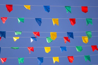 Mavi gökyüzü, ipte sallanan renkli bayraklar, rüzgarda sallanan. Haziran festivali.