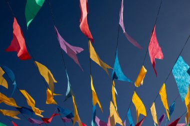  Arkaplanda mavi gökyüzü olan, ipten sallanan renkli flamaları kapat.