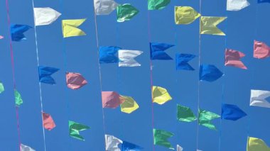 Açık ve güneşli bir günde rüzgarda hareket eden dekoratif bayraklar.