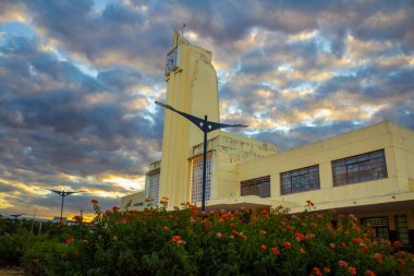 Eski Goiania Şehir Tren İstasyonu 'nun tarihi mimarisi, şimdi Frei Confaloni Müzesi, alacakaranlıkta, ön planda bir bahçesi olan.