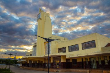 Eski Goiania Şehir Tren İstasyonu 'nun tarihi mimarisi, şimdi Frei Confaloni Müzesi, alacakaranlıkta, ön planda bir çiçek bahçesi ile.