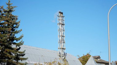 Kazan dairesinden çıkan beyaz duman mavi gökyüzünün arka planına karşı. İklim değişikliği kavramı. ev ısıtma.