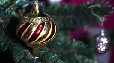 Noel ağacı dalında Noel süsü balosu. Yeni yıl geçmişi, bulanık, bulanık. Noel arkaplanı. Parlak renkli toplarla Noel ağacı süslemesi.