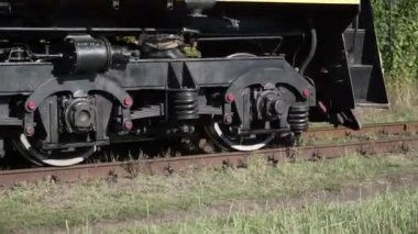 Locomotive wheels close-up. Old train locomotive. A moving train on a railroad track. Vintage technology background.