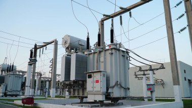 Power transformer. Electrical equipment. Electric substation. High voltage transformer against the blue sky. Electric current redistribution substation.