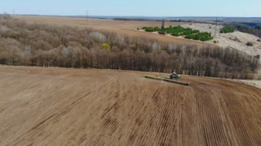 Ukrayna Vinnitsa 10 04 2022 İnsansız Hava Aracı ile traktör üzerinden uçarken harrow sistemi tarla sürerken toprağı tarlaya sürerken, toprağı yeni ekin, tarım konsepti, üst görünüm için hazırlarken.