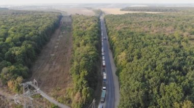 Tahıl teslimi. Hava görüntüsü. Tahıl deposu. Tahıl kamyonları tahıl ambarına giden yolda ayakta duruyor. Trafikte kamyonlar. Hasat ve ürün teslimatı. Tarım endüstrisi. Ağırlığa göre tahıl kamyonları