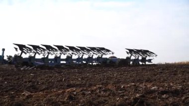 Tersine çevrilebilir ekici. Tersine çevrilebilir sabana sahip modern traktör tarlayı sürüyor. Bir ekiciyle toprak ekimi..