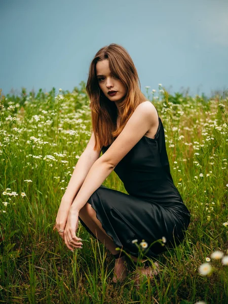 Schöne Junge Mädchen Einem Schwarzen Abendkleid Posiert Hockend Vor Einem — Stockfoto