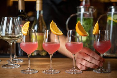 Adam servis masasından kokteyl alıyor.