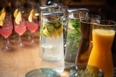 İçki masasında servis edilen limonata ve meyve suyu dolu kavanozlar.